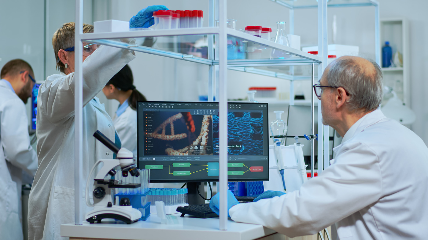 Two scientists in a laboratory, one reviewing a DNA visualisation on a monitor