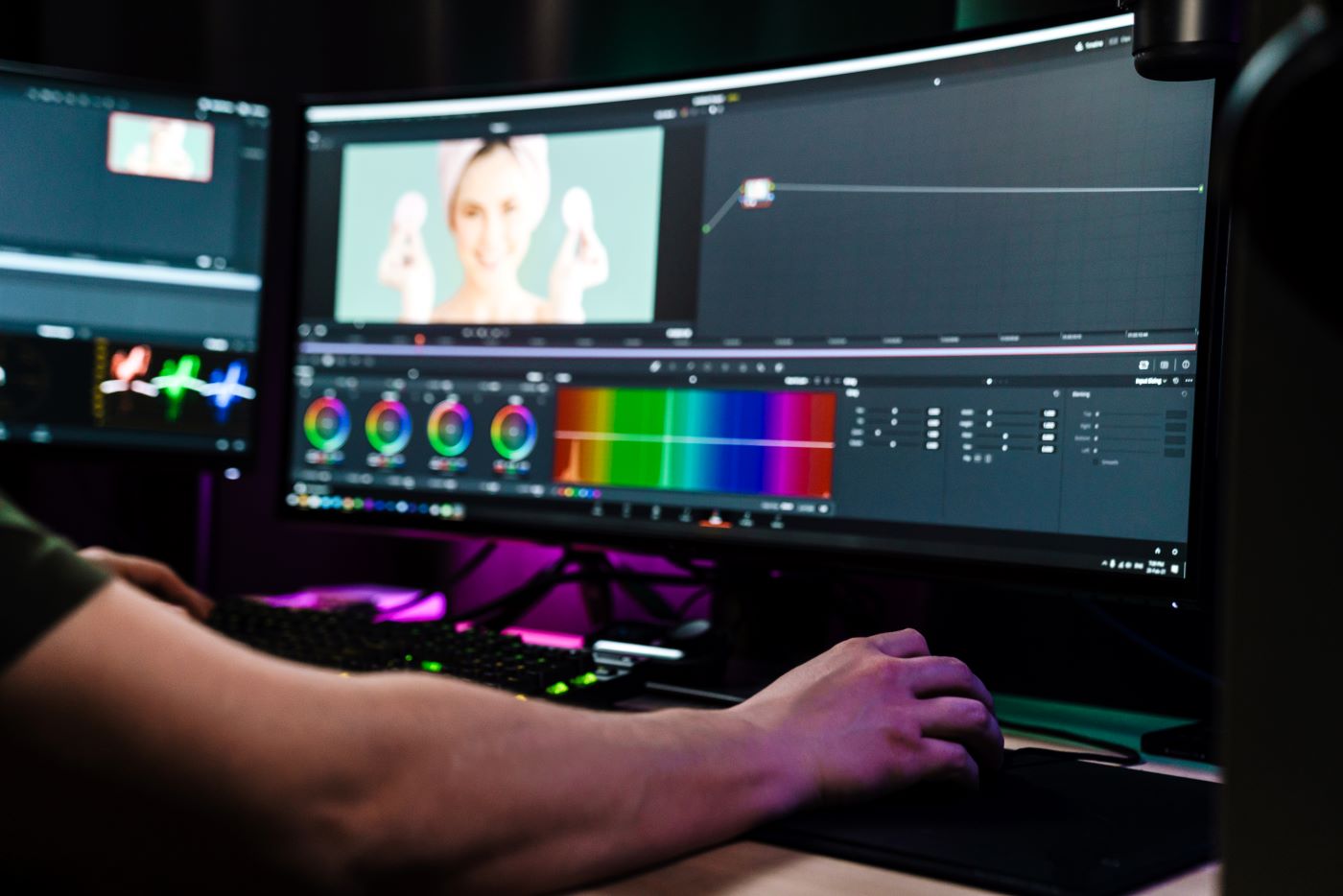 A video editor colour-grading footage at a workstation