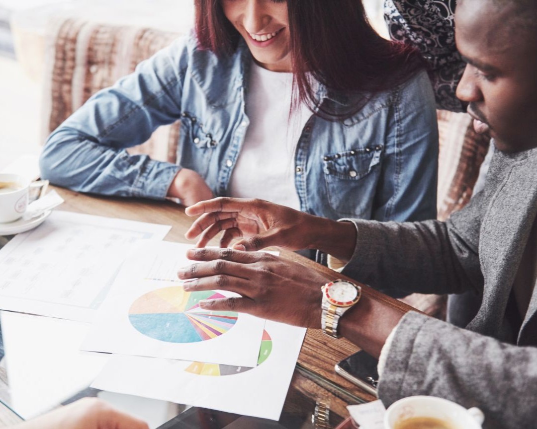A marketing team reviewing printed charts around a table