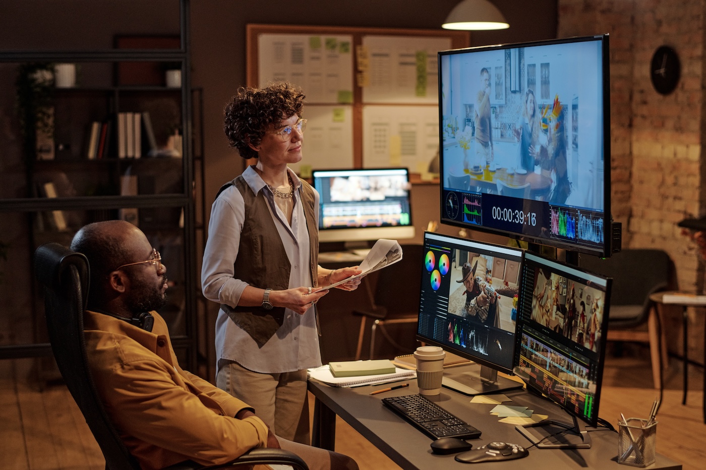 A production team reviewing video edits on large monitors in a studio