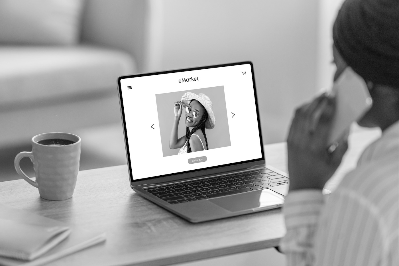 A laptop showing an online fashion store page while a woman talks on the phone