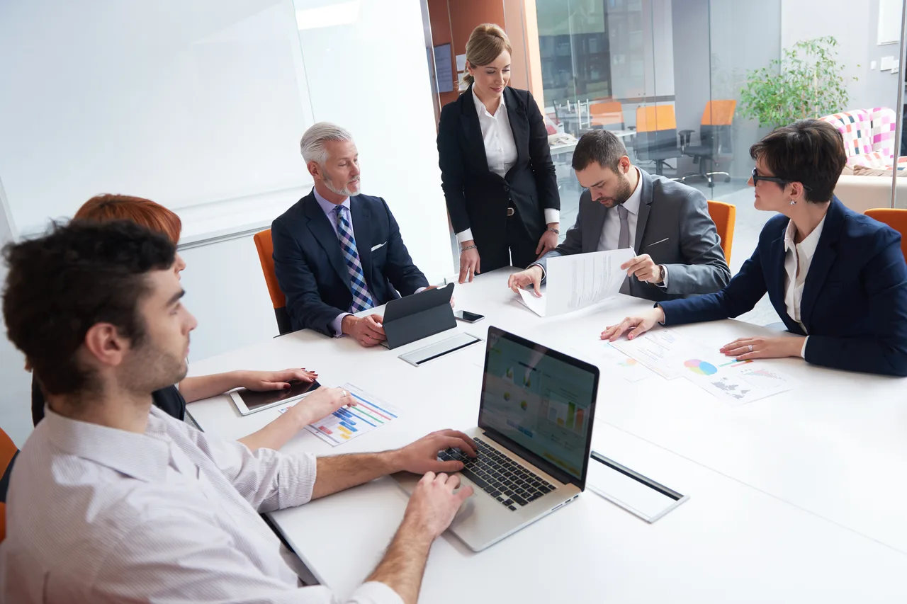 A finance team discussing figures around a meeting table