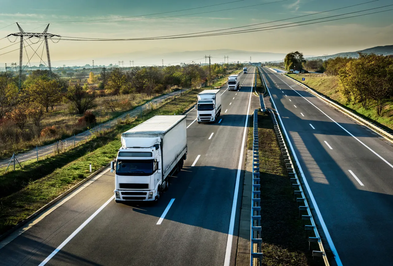 Lorries travelling along a motorway through open countryside