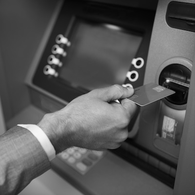 A customer inserting a card into a self-service banking machine