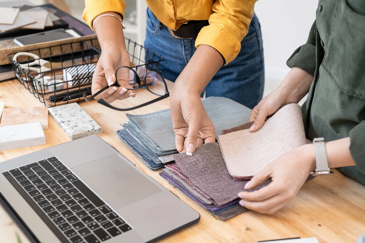 Designers sorting fabric swatches beside a laptop
