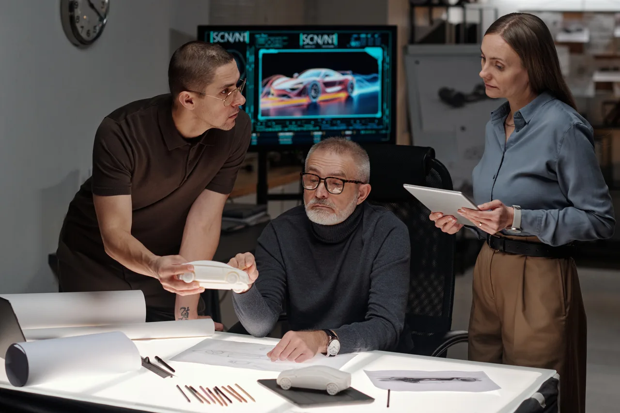 An automotive design team reviewing a vehicle model on screen