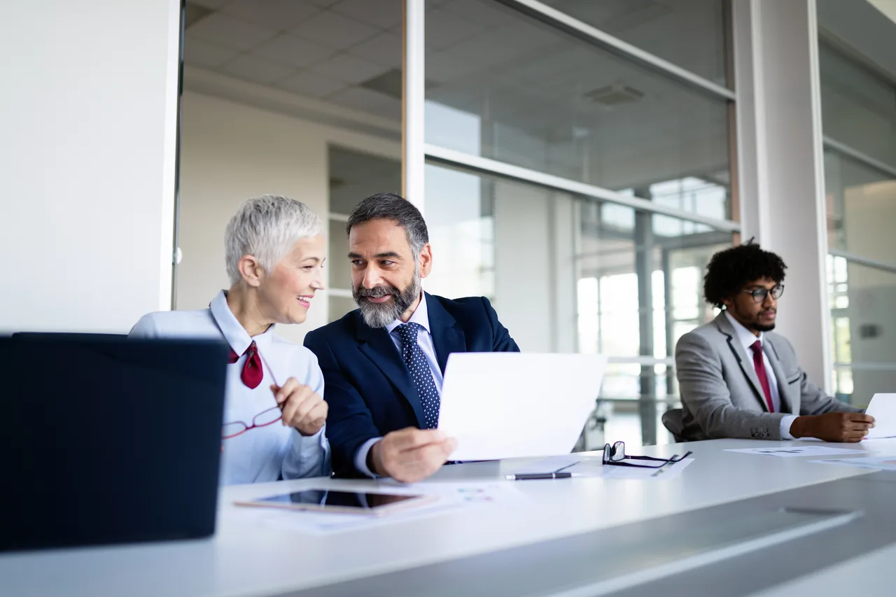 Banking leaders meeting around a table in a bright office