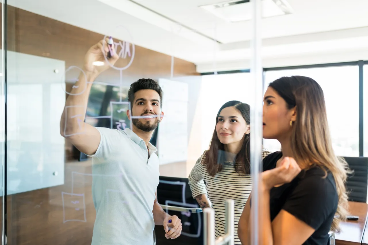 A team mapping out a sequence on a glass wall