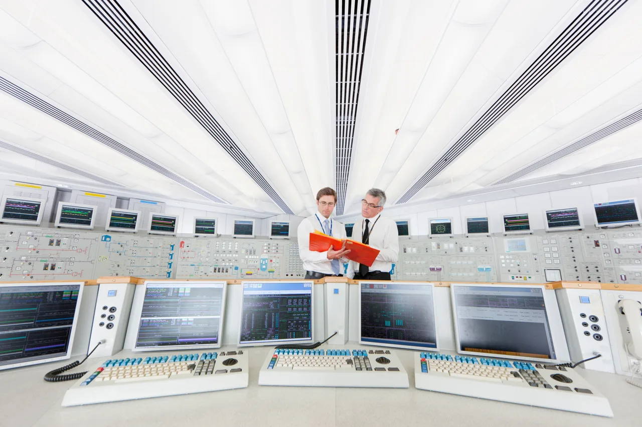 Two operators reviewing data in a plant control room