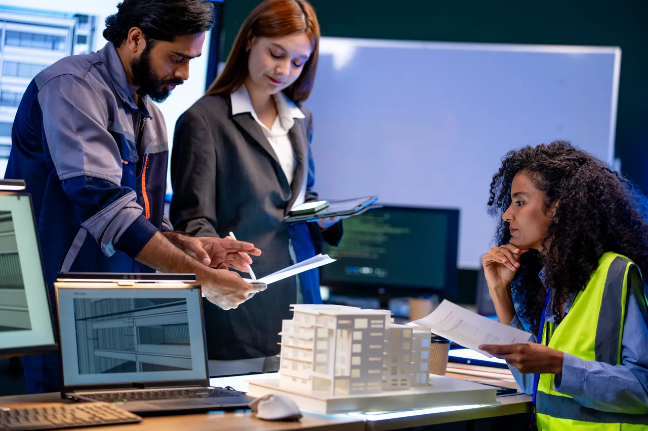 An architecture and engineering team reviewing a building model and drawings