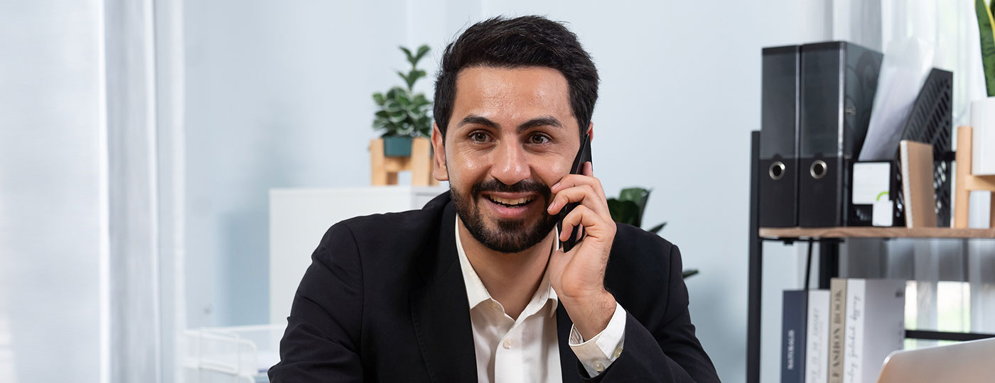 A man in a suit taking a phone call in an office