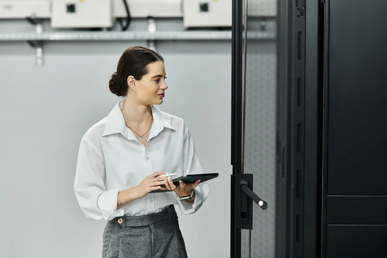 An IT engineer checking server equipment on a tablet