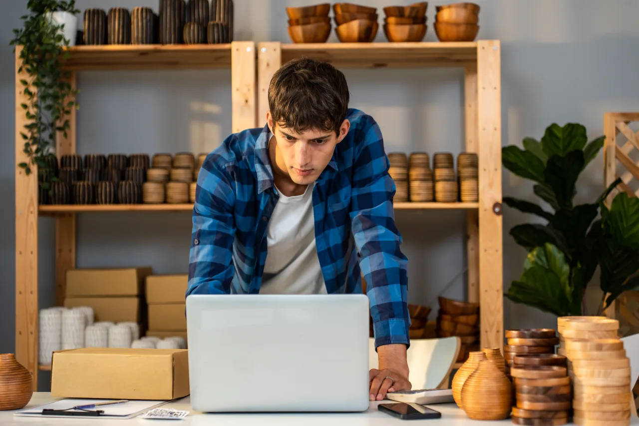 An online seller working on a laptop surrounded by stock