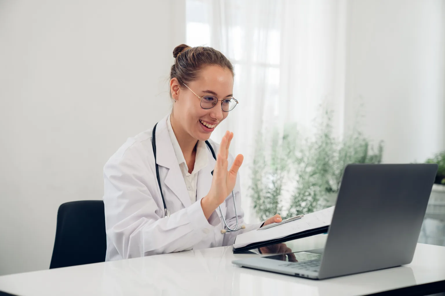 A doctor greeting a patient on a telehealth video call