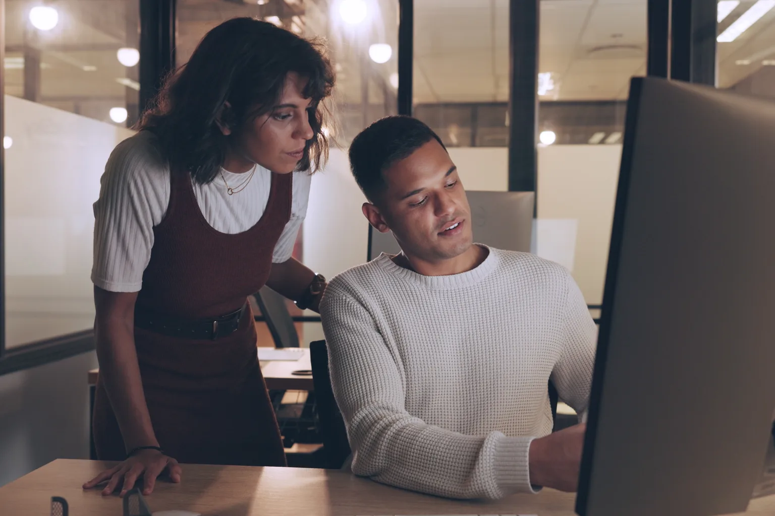 Two colleagues reviewing work together on a shared screen