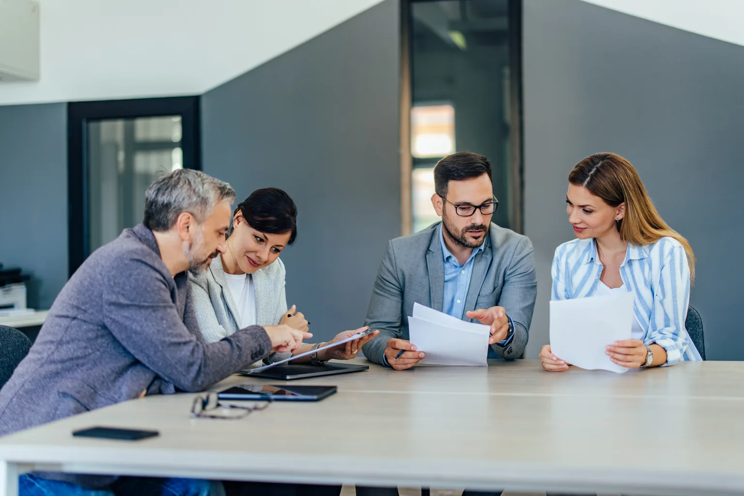 A team reviewing documents together around a meeting table