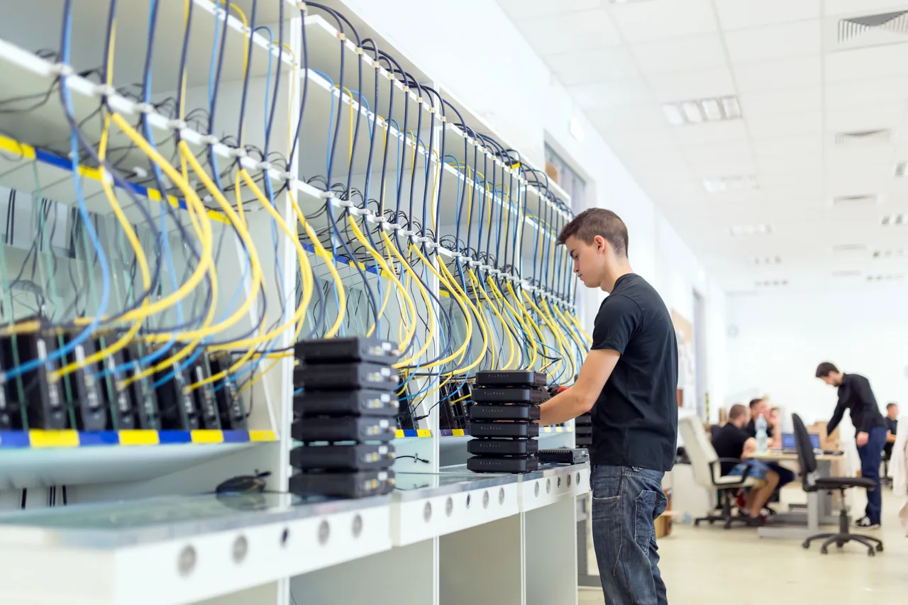 An IT technician connecting network cables in a server room