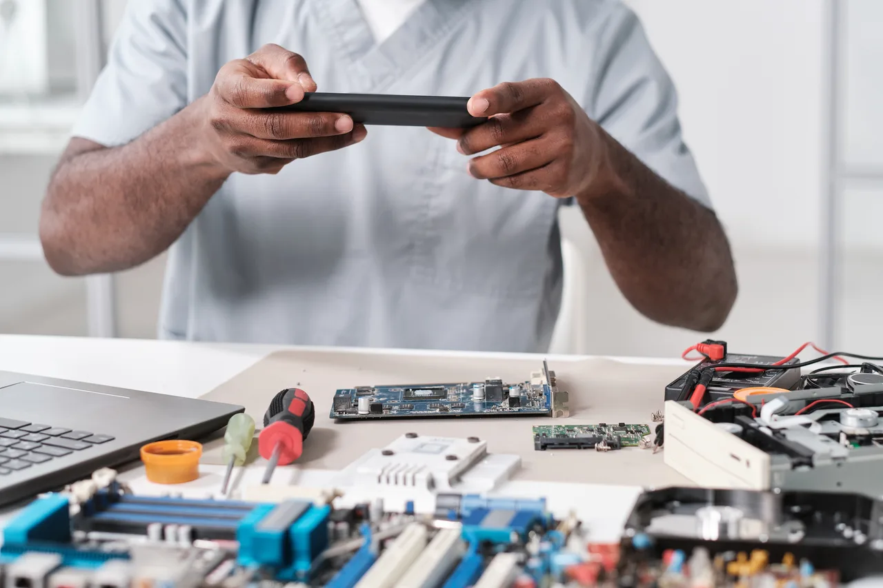 A technician photographing returned components for repair records
