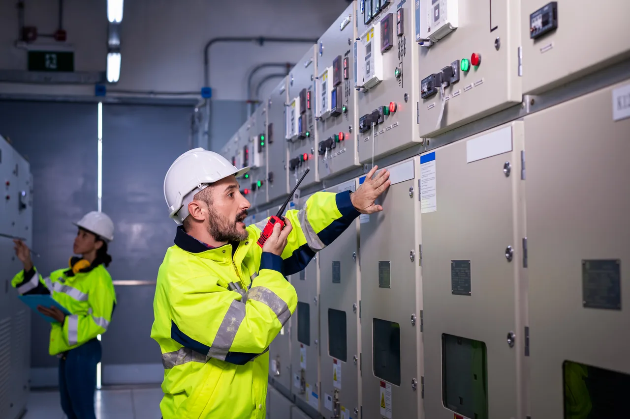 Two engineers inspecting electrical switchgear panels
