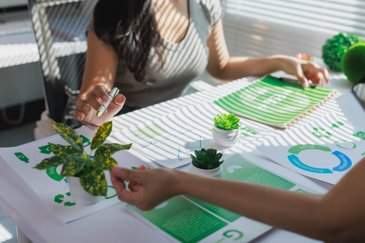 Two people reviewing sustainability reports at a desk