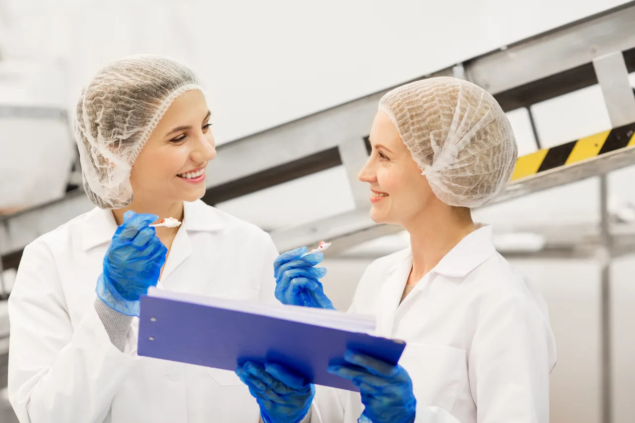 Two quality specialists reviewing documentation in a food plant