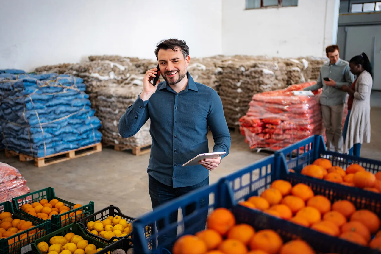 A produce distributor on a phone call in a fresh-food warehouse