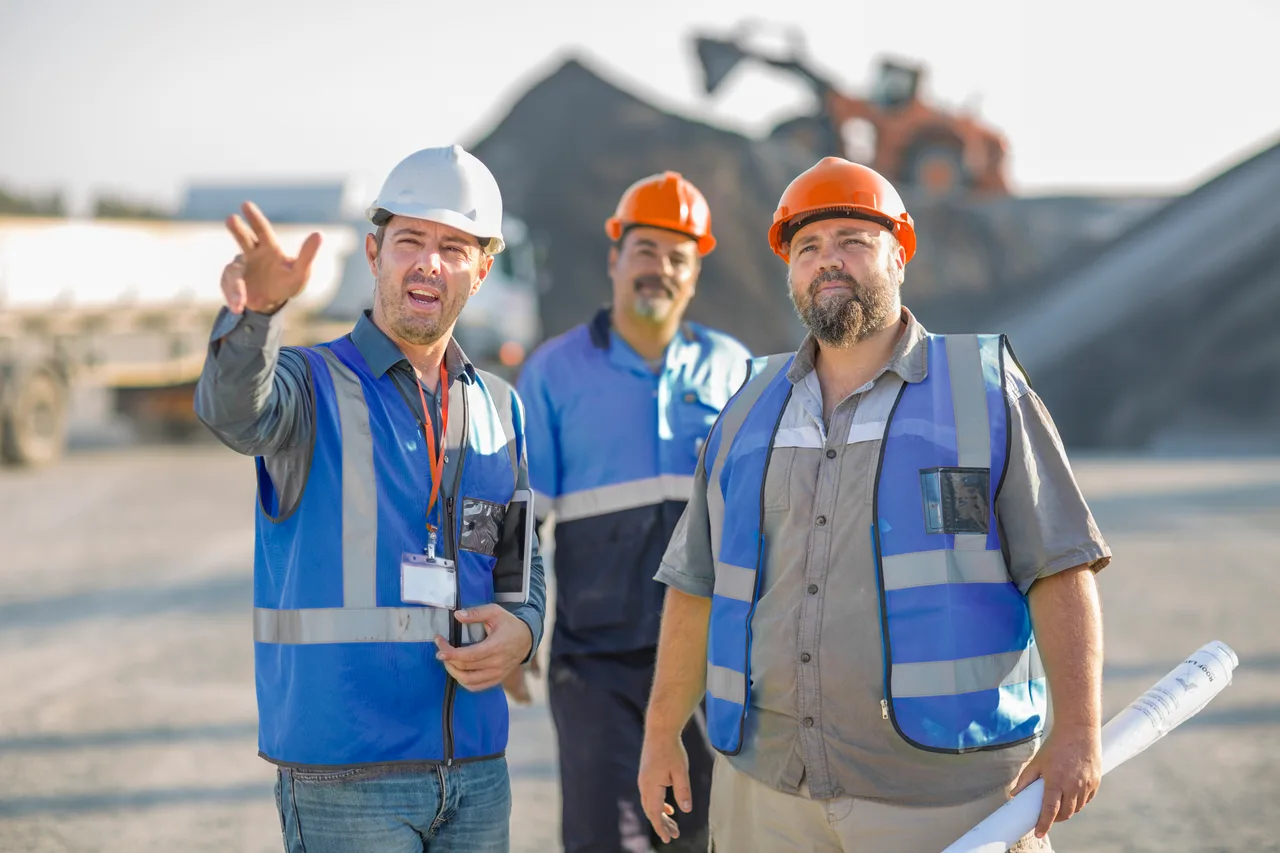 Three site engineers surveying an extraction site