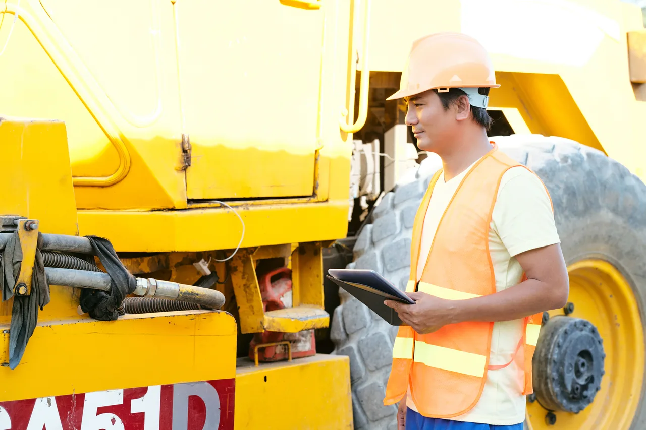 A contractor checking heavy haul equipment on a tablet