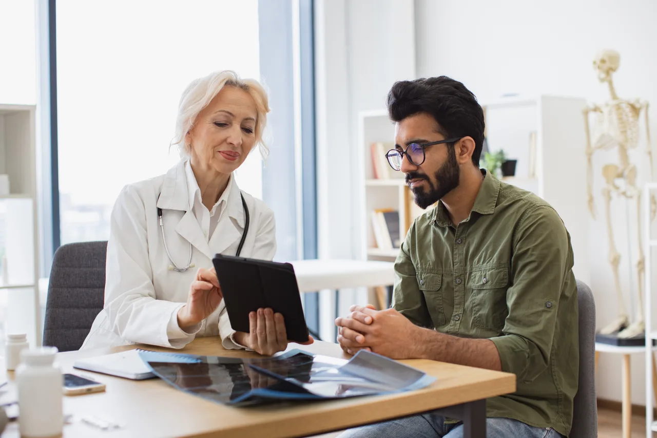 A clinician reviewing results on a tablet with a study participant