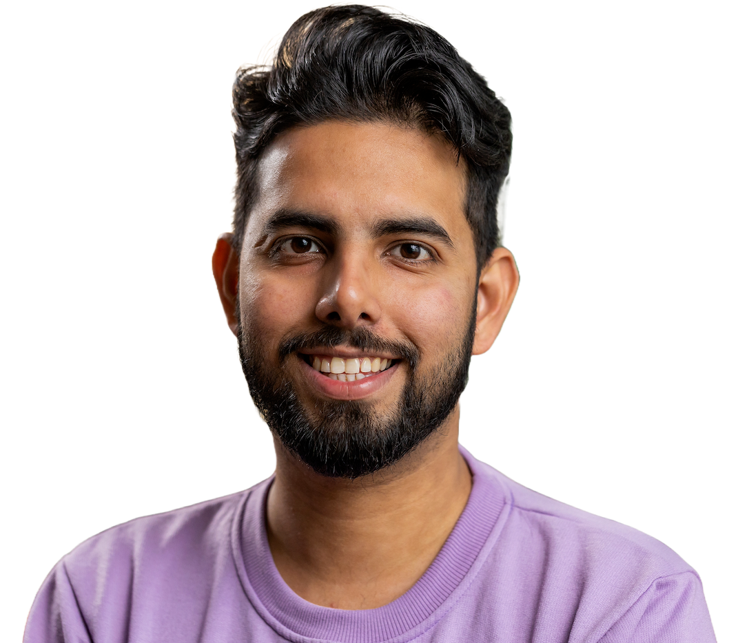 A smiling engineer with dark swept-back hair and a beard in a lilac sweatshirt