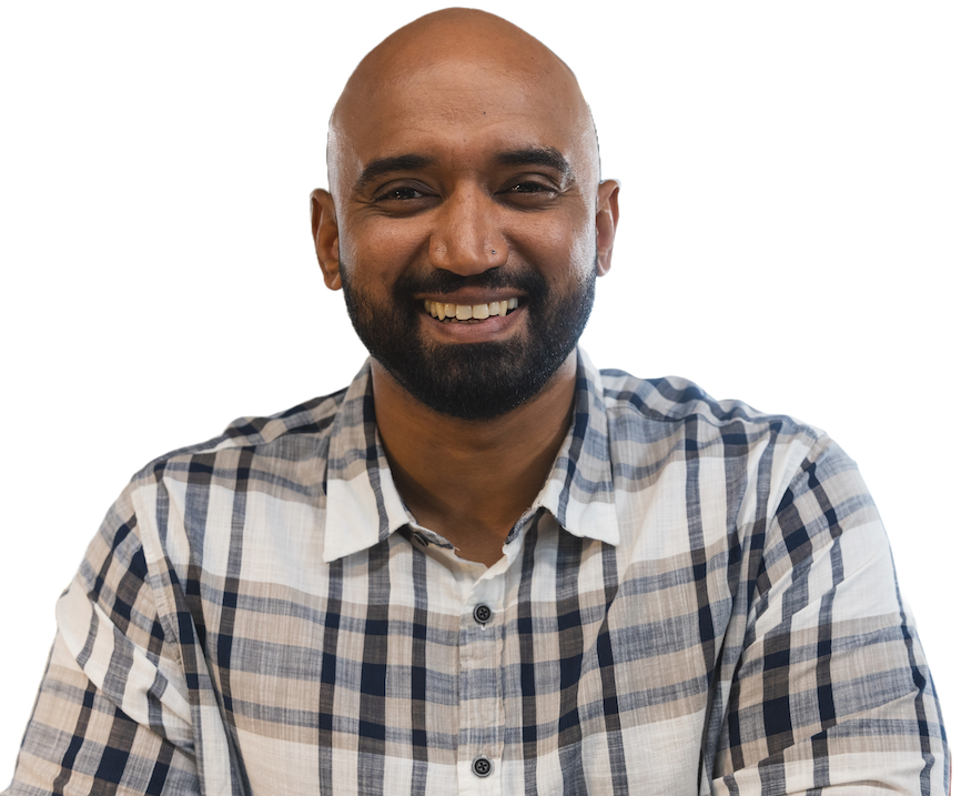 A smiling bald engineer with a dark beard in a checked shirt
