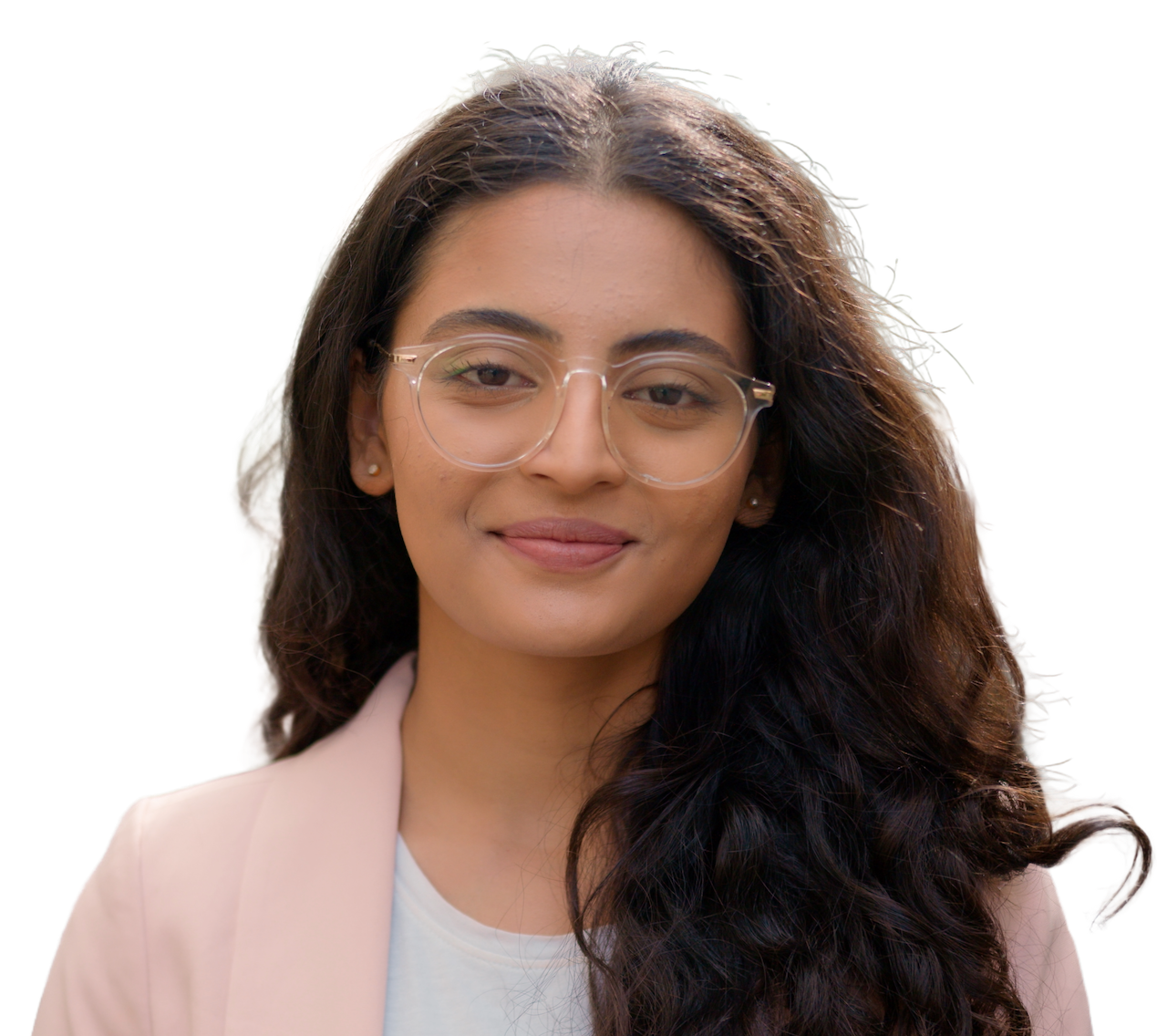 A smiling engineer with long wavy hair and clear-framed glasses, in a pale pink blazer