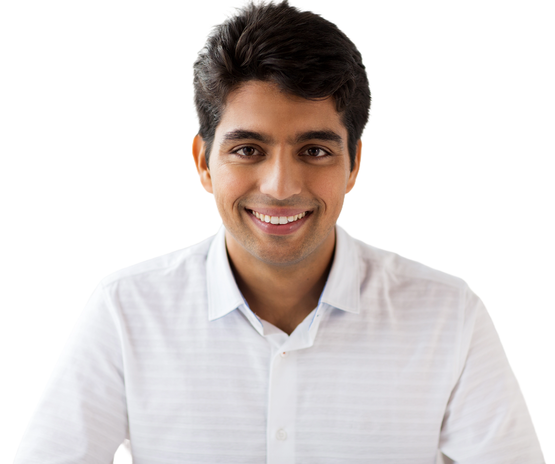 A smiling engineer with short dark hair in a white open-collared shirt