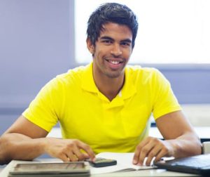 cheerful male indian college student in lecture room