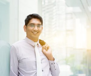 young happy indian employee working on laptop
